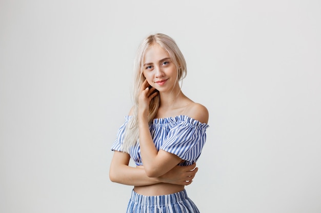 Playful beautiful blonde girl in summer outfit isolated