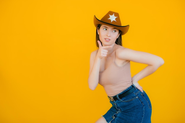 Playful beauty in country style Beautiful young woman in cowboy hat