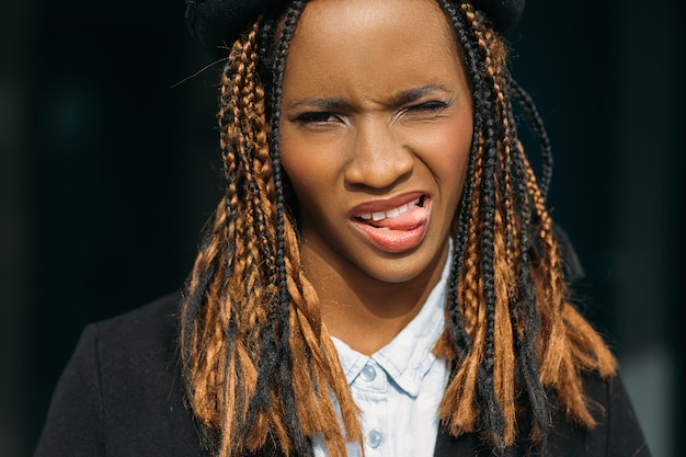 Playful black female portrait. Seductive mood. Modern youth behavior, funny African American woman on dark background, stylish lifestyle, joy concept