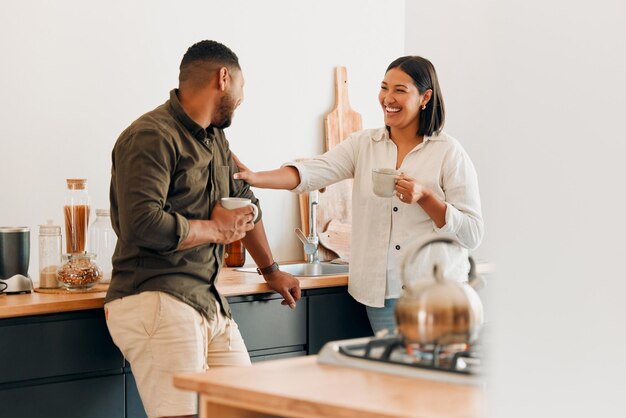 Photo playful coffee and loving couple bonding and having fun together in the kitchen at home smiling in love and carefree couple laughing and sharing a romantic moment while enjoying the weekend