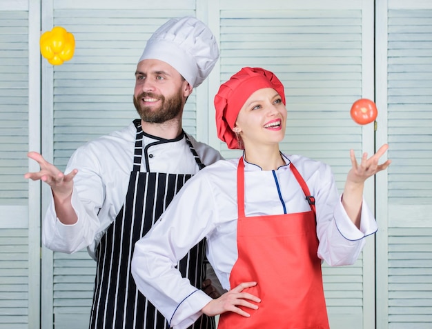 Playful culinary master family cooking in kitchen happy couple\
in love with healthy food dieting and vitamin culinary cuisine man\
and woman chef in restaurant vegetarian cook uniform