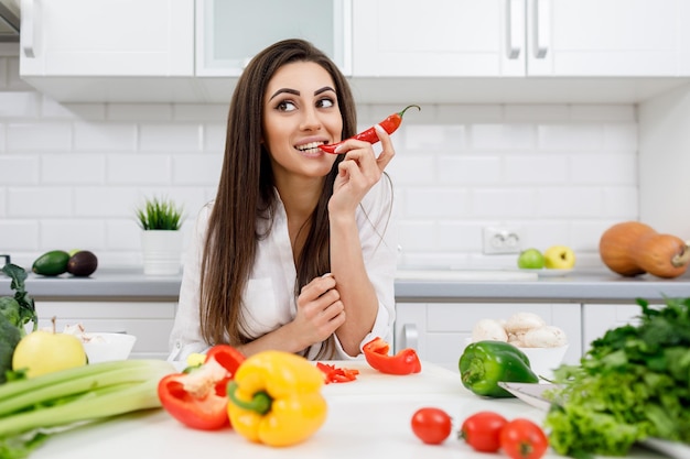 Playful Cute Brunette Girl Biting Chili Pepper Tip