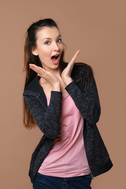 Playful girl making duckface isolated on beige wall