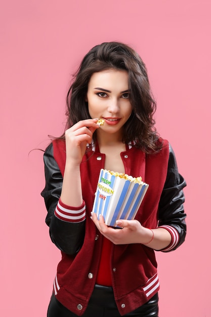 Playful girl with pack of popcorn