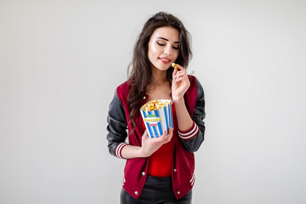 Playful girl with pack of popcorn