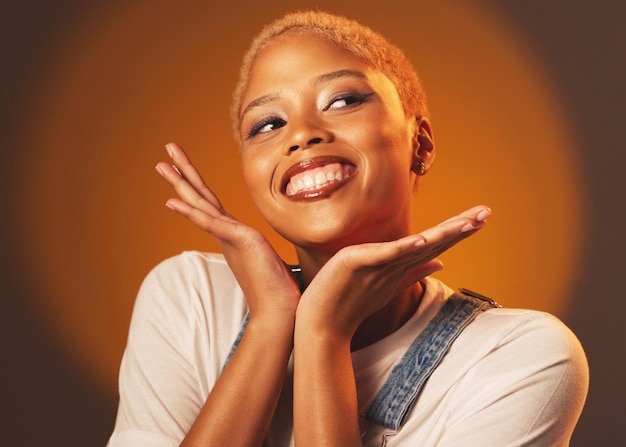 Playful happy and beautiful black woman with hands isolated on a brown studio background Crazy funny and African girl with perfect makeup cosmetics and excited to show face on a backdrop