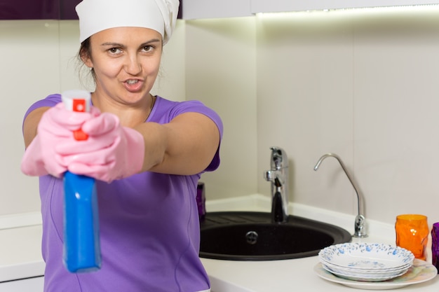 Playful housewife aiming the spray bottle