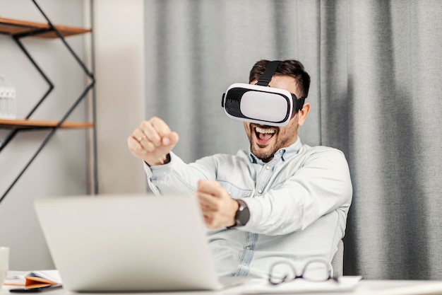 A playful man playing VR game driving a car at his home office