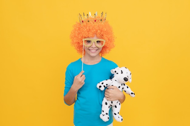In playful mood april fools day just having fun fancy party look egocentric kid in clown wig and crown imagine herself princess funny child in party glasses selfish teen girl in tiara with toy