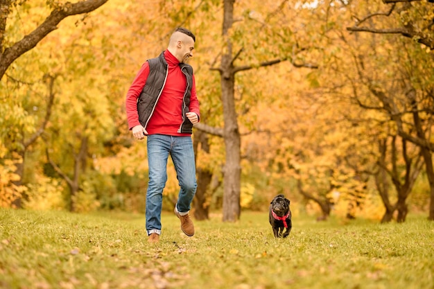 遊び心のあるムード。公園で犬と遊ぶ男