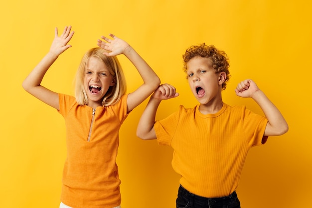 Playful siblings against yellow background