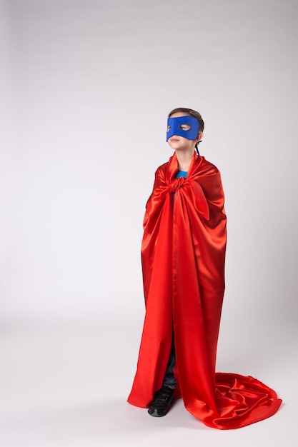 Playful superman kid posing in studio