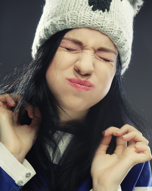 Playful young woman in funny winter hat