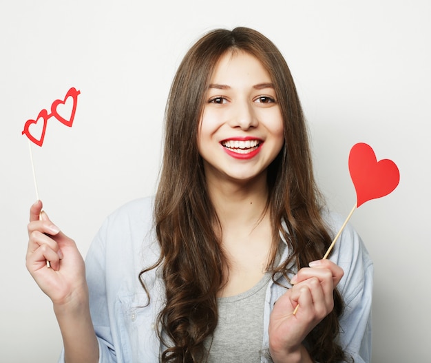 Playful young woman holding a party heart.