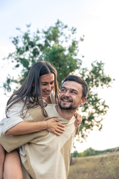 playful and youthful adult man and woman having fun together in the meadow