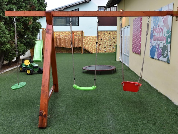 Foto parco giochi per bambini con altalene trampolino trattore e parete da arrampicata