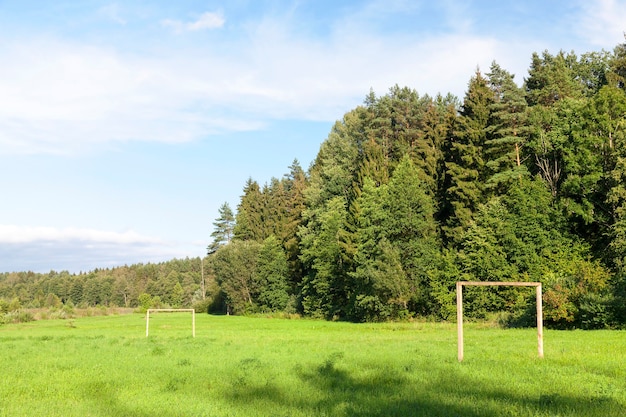 Playground in the countryside, designed for training and playing football. The territory of the forest. Photo closeup visible gate made of logs.
