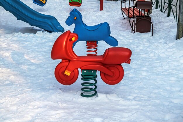 playground in winter on a sunny daybright plastic swing