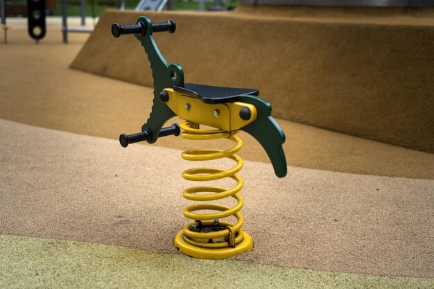 A playground with a yellow spring and a green handlebar