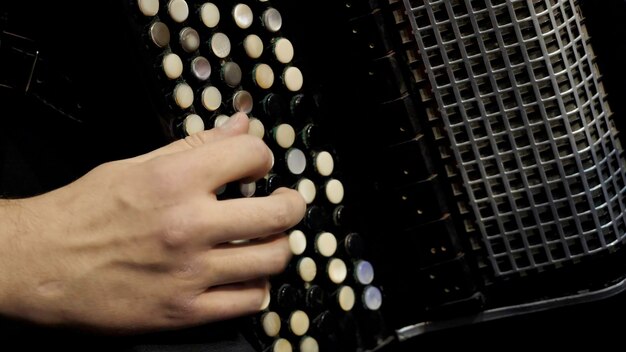 Playing on a big accordion Playing the harmonica closeup