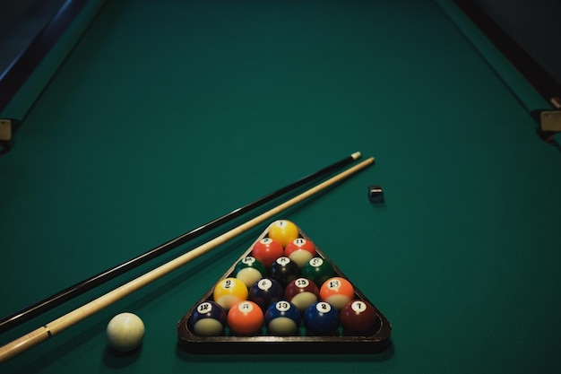 Playing billiard Billiards balls and cue on green billiards table Billiard sport concept