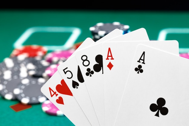 Playing cards and chips on green casino table