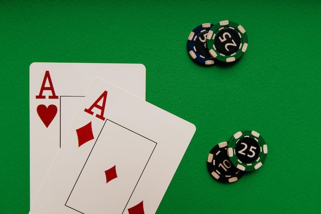 Playing cards with aces and chips on a green table closeup casino concept