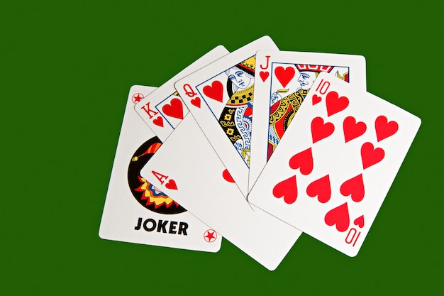 Playing cards with a joker on green