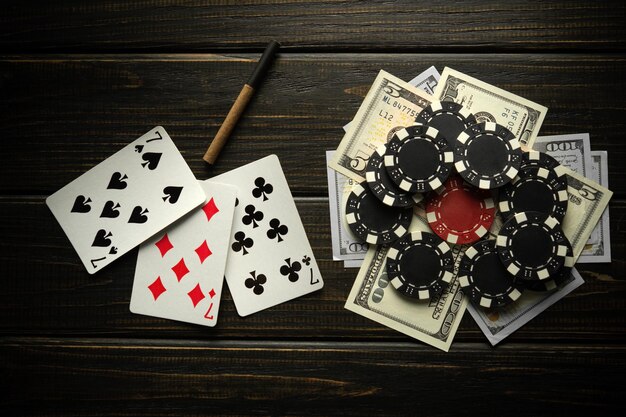 Playing cards with a winning combination of three of a kind or set and money with chips on a black vintage table Winning in sports or poker depends on luck