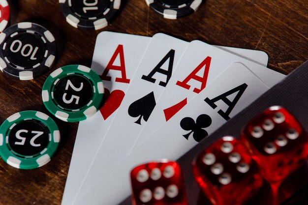 Playing chips dices and cards on a wooden table closeup