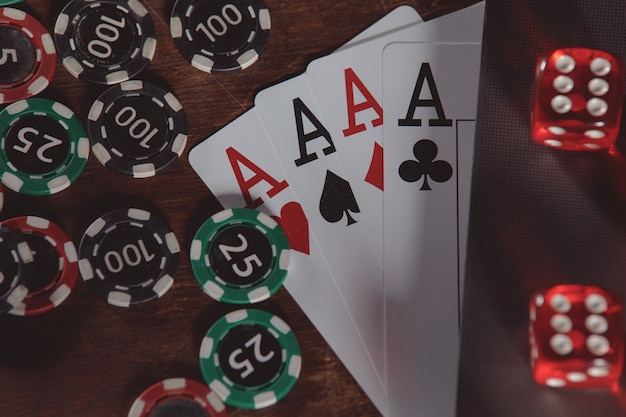 Playing chips red dices cards with aces and laptop closeup