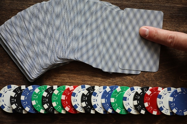 Playing chips on a wooden texture table and a deck of cards