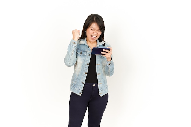 Playing Game on Phone with Happy Face of Beautiful Asian Woman Wearing Jeans Jacket and black shirt