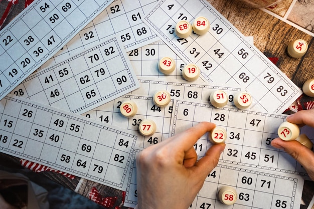 Photo playing lotto game person holding cube with figure on bingo card background nostalgia lifestyle