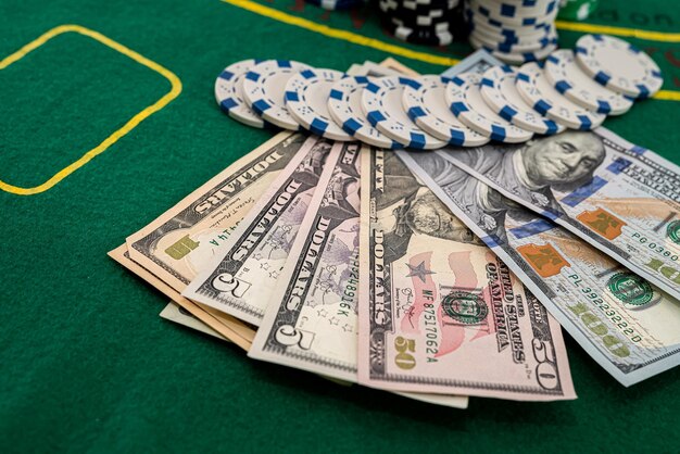 Photo on the playing poker table are colored chips on top of each other and dollars next to them. poker concept