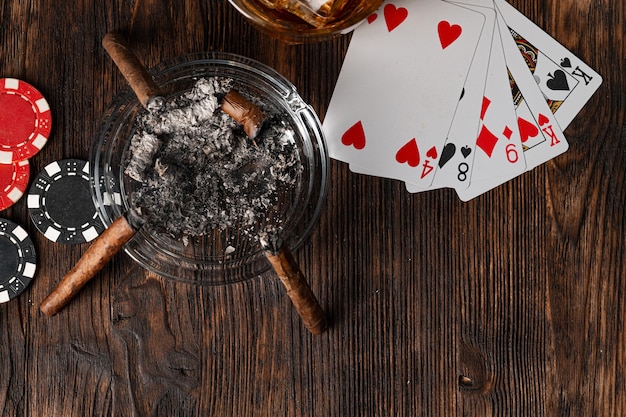 Playing poker with whiskey and cigars on table