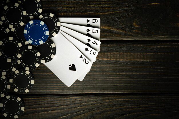 Playing poker with a winning straight flush combination Cards with chips on a black vintage table in a poker club