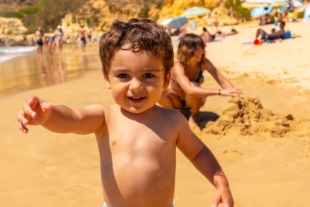 Playing in the sand on the beach at Praia do Barranco das Belharucas Albufeira Algarve Portugal