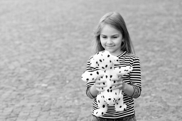 그녀의 새 장난감을 가지고 노는 것 행복한 아이가 야외에서 장난감 개와 노는 것 게임 및 놀이 어린 시절 활동 유치원 및 놀이 학교 장난감 가게 아기를 즐겁게 하는 복사 공간