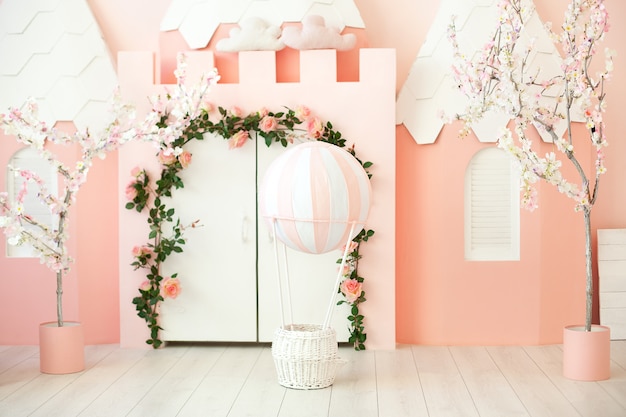 Playroom with pink castle tent for children. Children's room. Decorations for a children's party. A room with tent, white door and balloon. Kindergarten