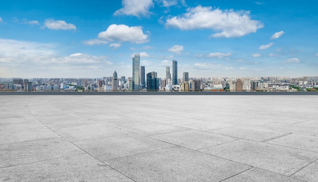 プラザの床タイルと都市の建物グループの背景