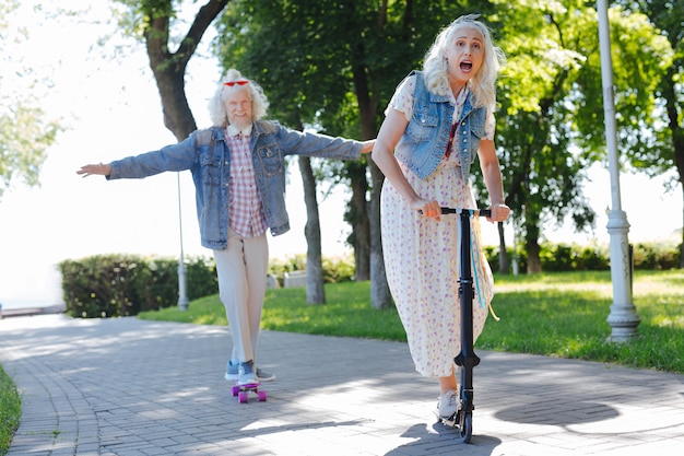 Pleasant activities. Joyful elderly people having fun while spending time in the park