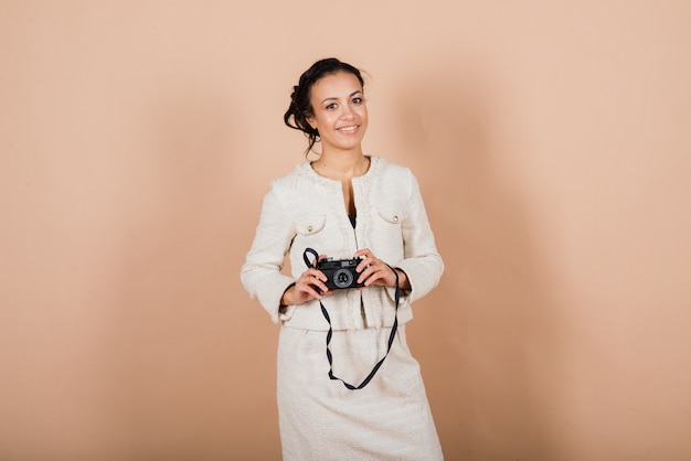 Photo pleasant african young woman holding camera