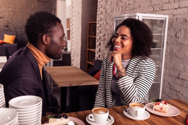 Pleasant conversation. Joyful positive couple talking to each other while having coffee