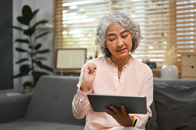 Pleasant middle age woman checking social media shopping online ordering delivery on digital tablet