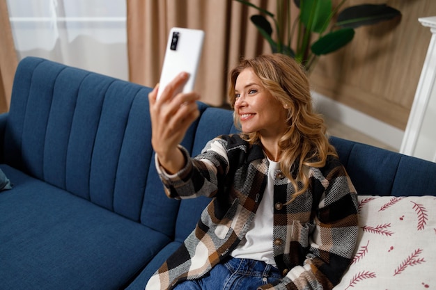 Pleasant middleaged woman sitting on the sofa in the living room