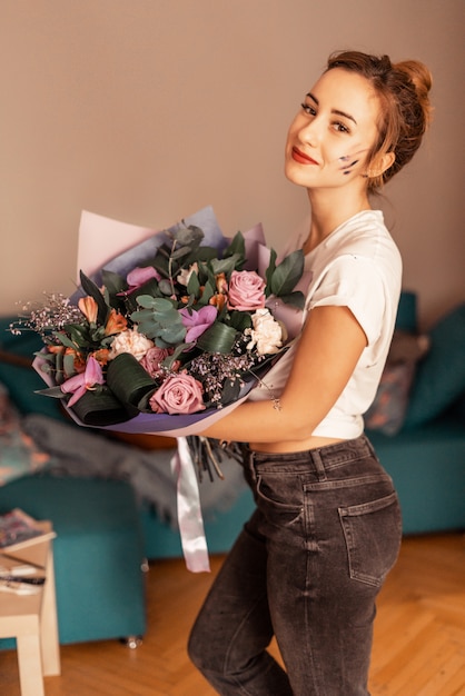 人生の楽しい瞬間。花の花束を持つ美しい少女。休日、贈り物としての花。粒で。