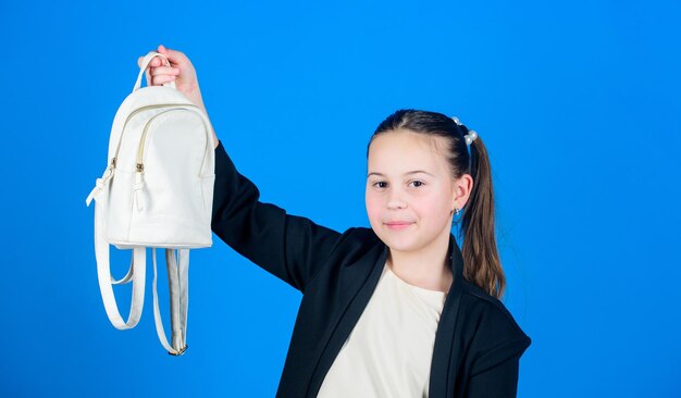 Pleasant shopping Adorable girl with small bag Small girl with shopping bag Girl child enjoy shopping Cute child holding bag on blue background Little girl going shopping with daypack bag