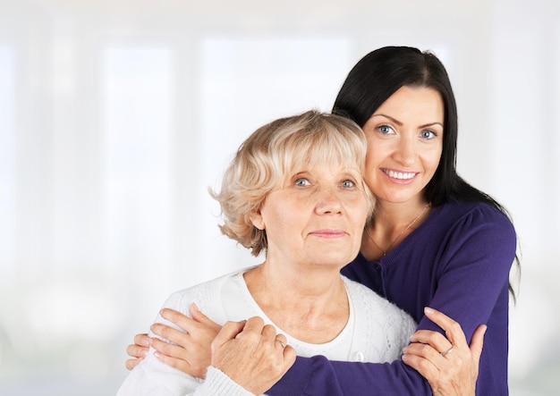 Pleasant woman and her mother embracing