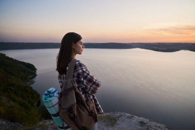 Foto piacevole donna in piedi sulla collina e guardando il tramonto